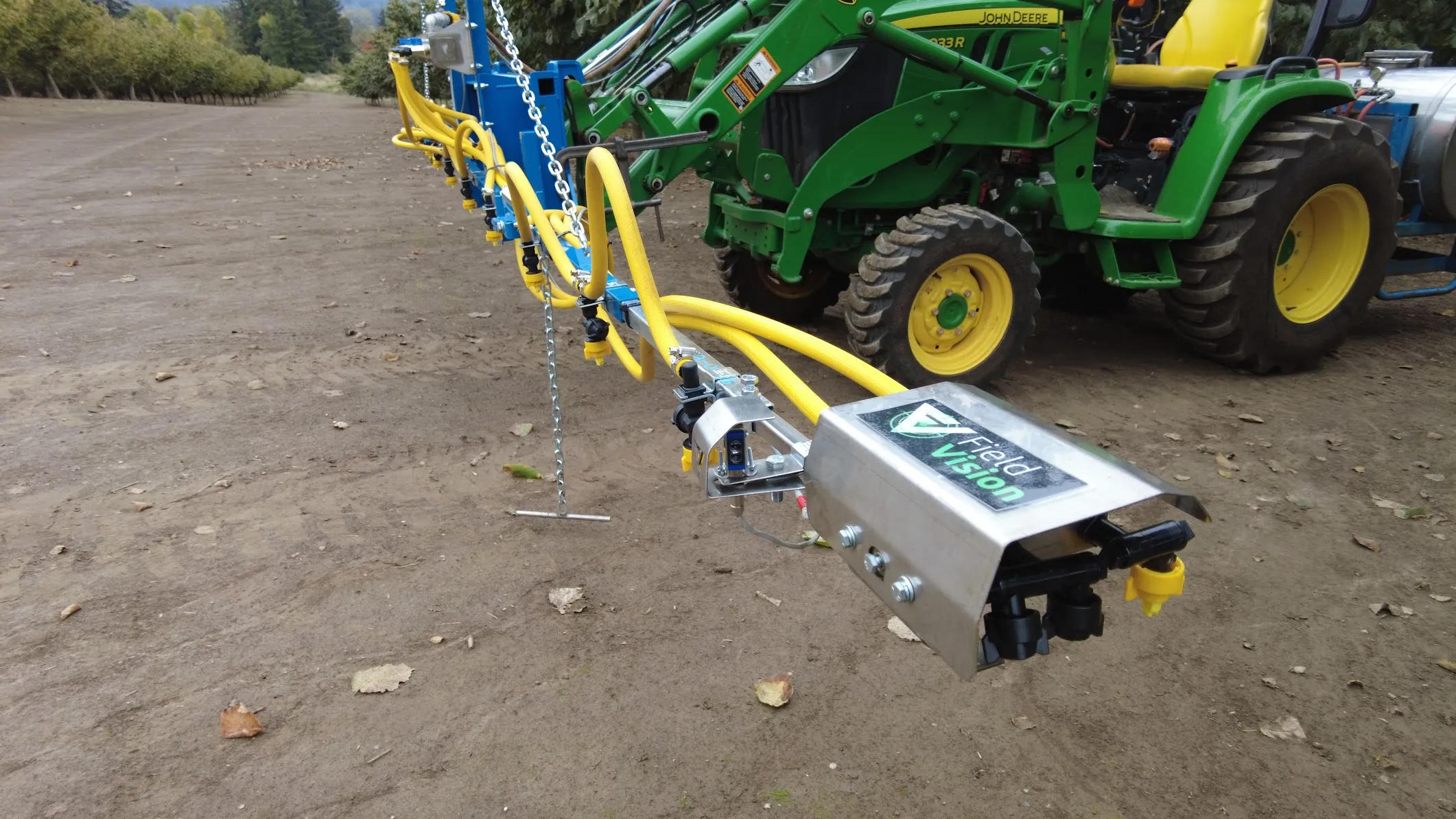 FieldVision agricultural spray sensor mounted on an orchard boom beside a tractor